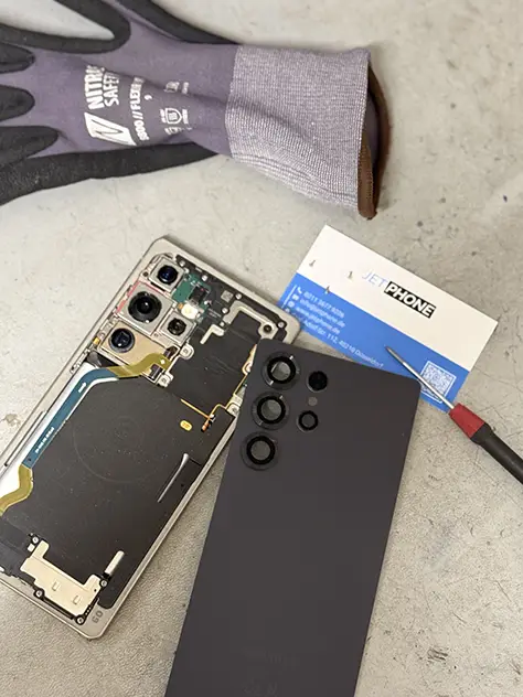 Geöffnetes Samsung Galaxy S25 Ultra mit abgenommener Rückseite und sichtbaren Kameramodulen in der Werkstatt
